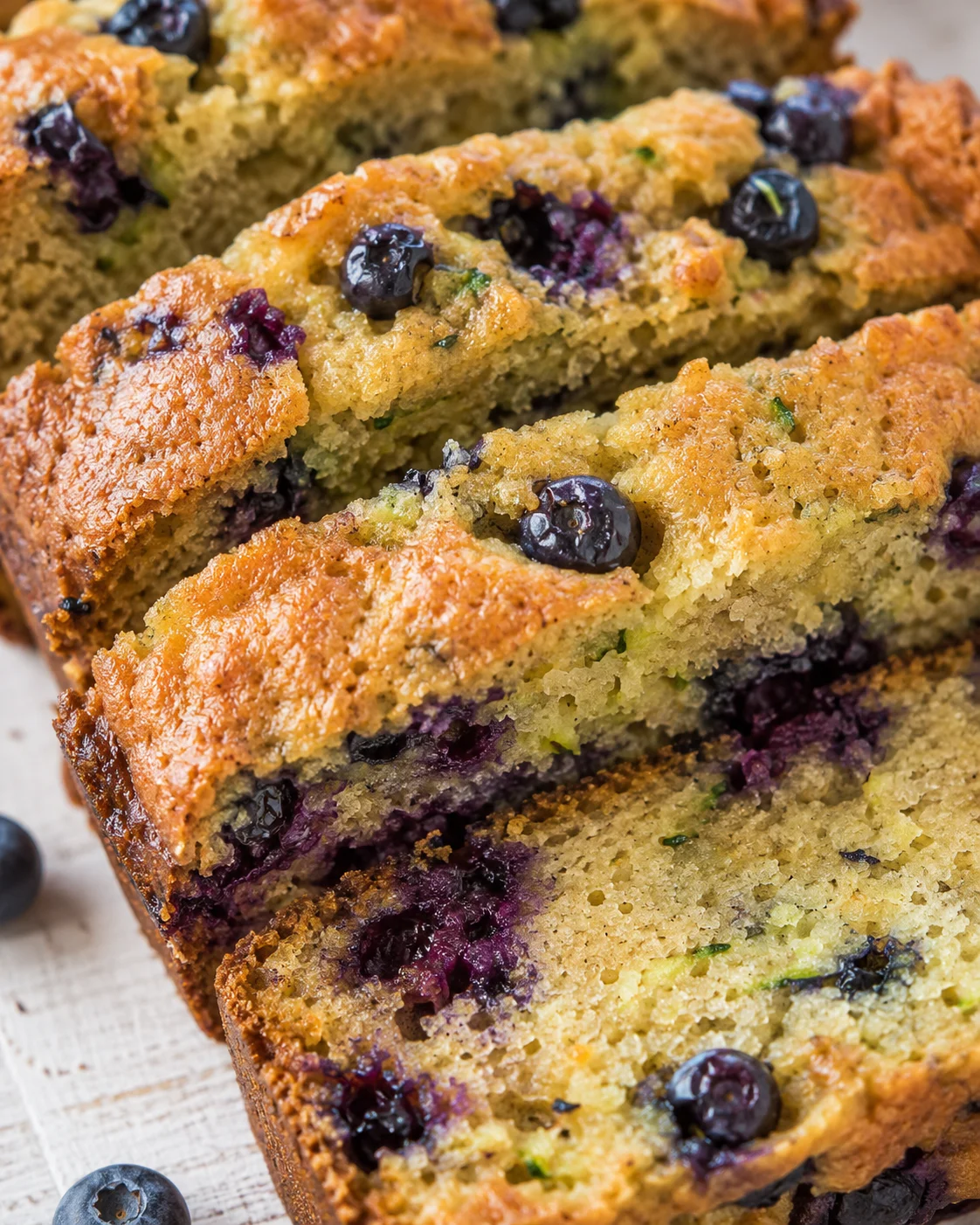 Blueberry Zucchini Bread Close-up of juicy blueberry zucchini bread slices with blueberries inside.