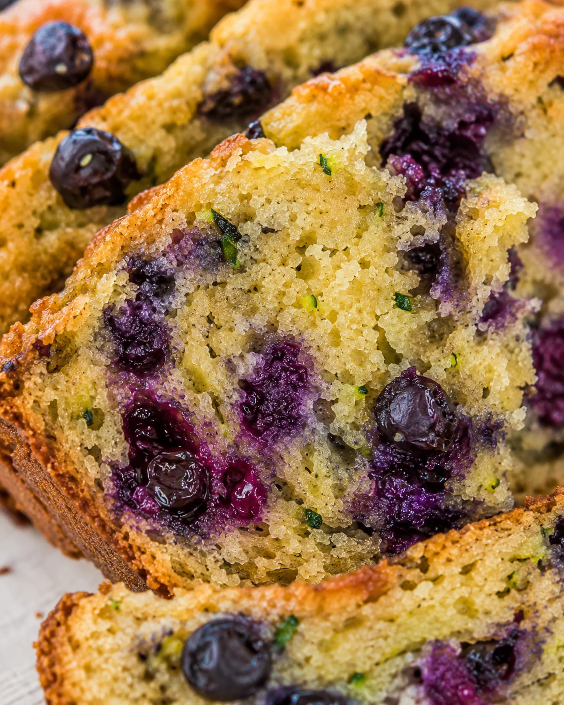 Blueberry Zucchini Bread Close-up of moist blueberry zucchini bread with blueberries and zucchini inside.
