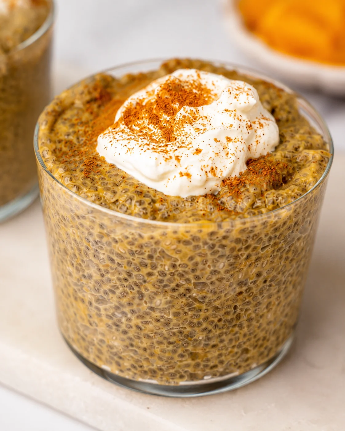 Pumpkin Chia Pudding Creamy pumpkin chia pudding topped with whipped cream and a sprinkle of spices.