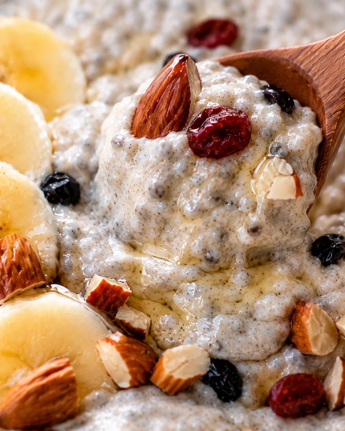 Close-up of creamy banana chia pudding topped with nuts and dried fruit.