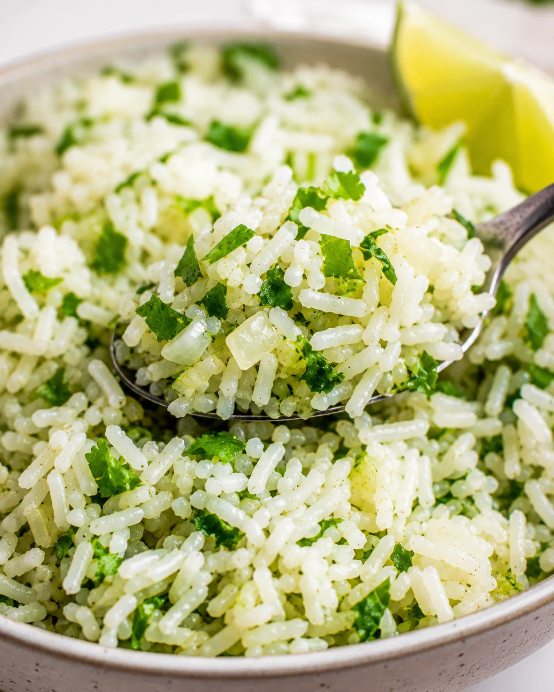 Spoonful of cilantro lime rice with lime wedge in background
