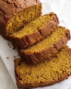 Sliced pumpkin bread loaf showing moist interior and golden-brown crust